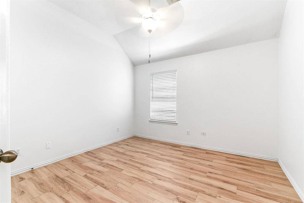 The oversized secondary bedrooms each feature spacious layouts, high ceilings, and closet space for storage. All rooms are equipped with ceiling fans and showcase the same wood-look tile flooring found throughout the home.