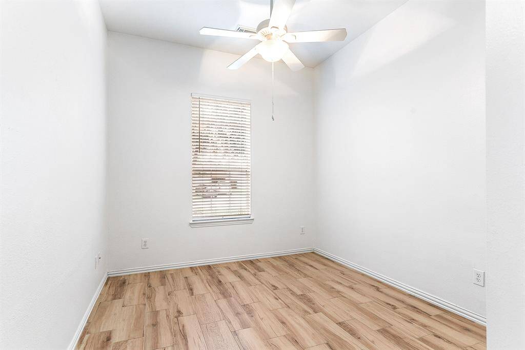 The oversized secondary bedrooms each feature spacious layouts, high ceilings, and closet space for storage. All rooms are equipped with ceiling fans and showcase the same wood-look tile flooring found throughout the home.