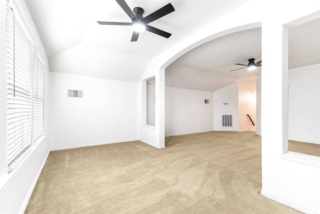 A view of this large space featuring a dividing wall, creating distinct areas for versatile use.