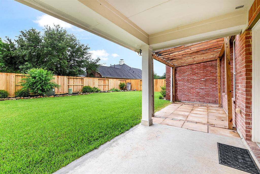 The large, custom-built extended covered patio offers ample seating for entertaining, making it perfect for both relaxing and hosting guests.