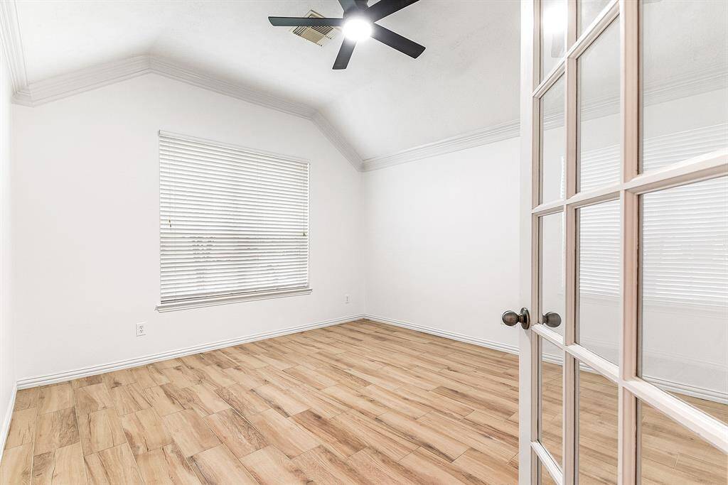 Glass doors lead into the private home office, offering serene views of the front yard.