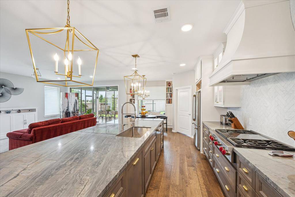 Dressed to impress with modern pendant lighting, the kitchen boasts a Wolf gas cook top with griddle, a Subzero Cove dishwasher, Faber vent hood, and recently installed (May 2025) Fridgedaire oven, LG microwave and Electrolux refrigerator.