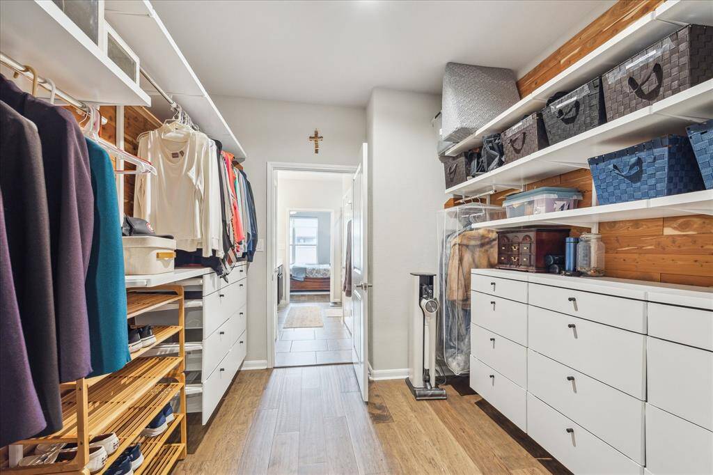 Conveniently located between the primary bathroom and laundry room, the primary closet has been outfitted with custom Elfa shelving and drawers.