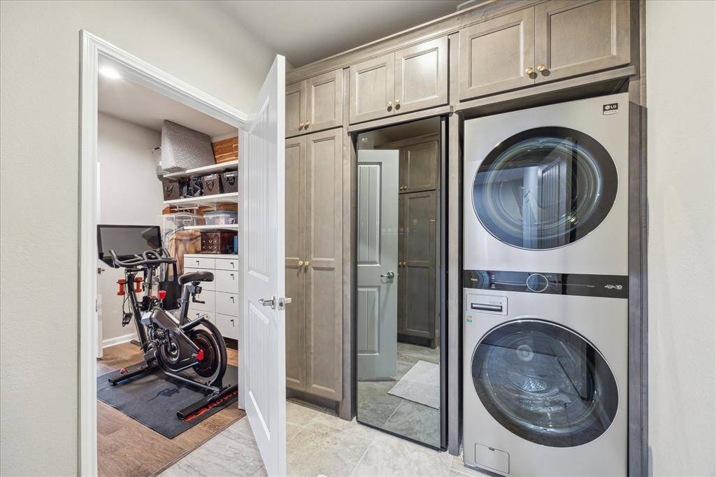 Conveniently located just off the primary closet, the laundry room was retrofitted by the current owners to accommodate a stackable washer and dryer and additional storage cabinets.  Please note:  the steamer to the left of the washer/dryer will not convey with the sale.