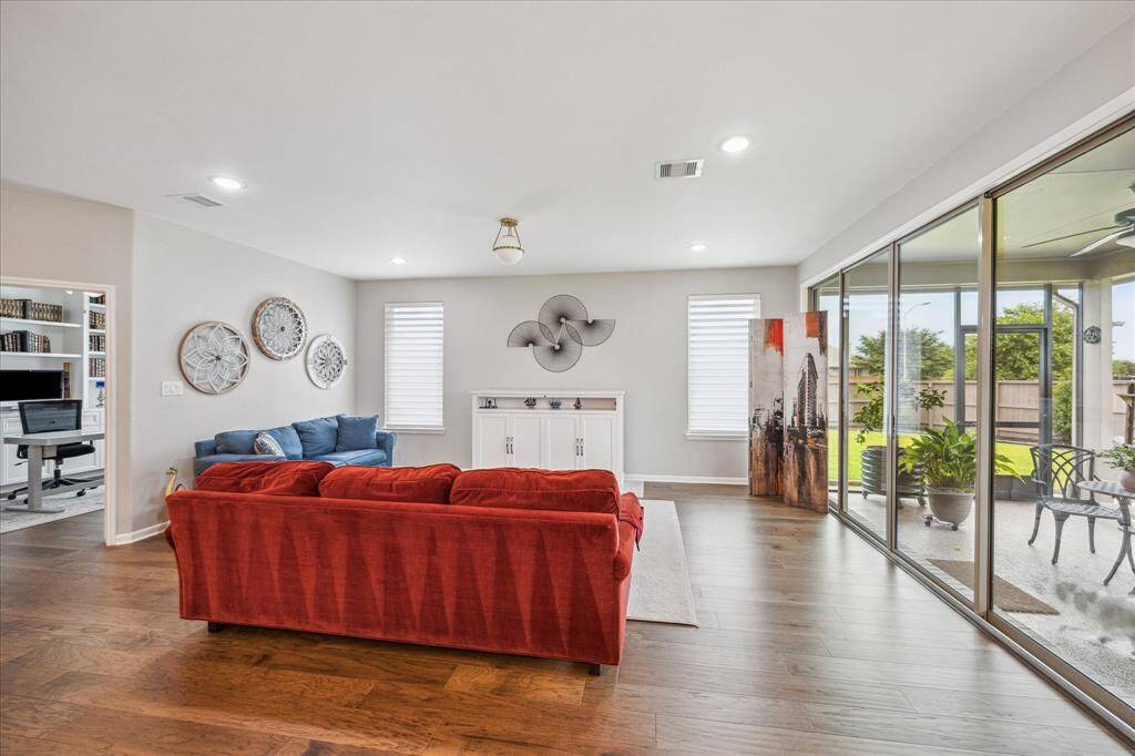 This view of the family room shows the study on the far left and the "window wall" provided by the sliding glass doors with side glass inserts. The window shades in the study, family room, and breakfast room are automated and can be controlled from your phone,