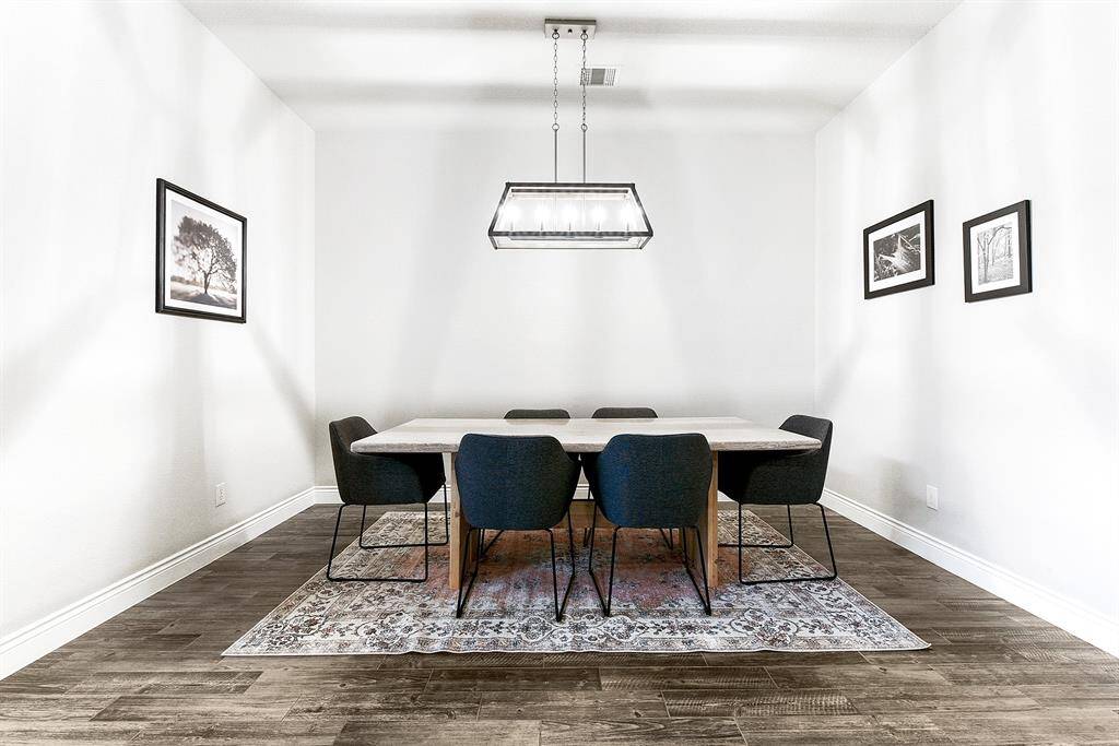 An alternative perspective of the formal dining room highlights its seamless connection to the kitchen. It comfortably accommodates a large dining table with room for additional furniture if desired.