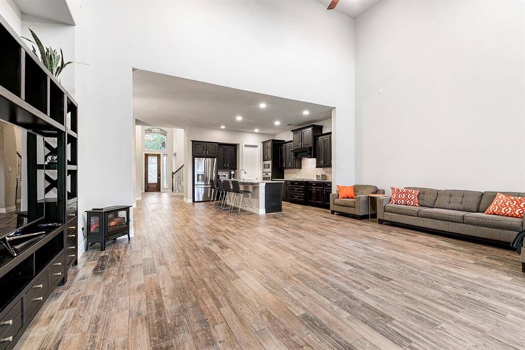 A fantastic space on the main floor offers seamless flow between the kitchen, living room, formal dining room, and front entry all featuring beautiful wood-look tile flooring.