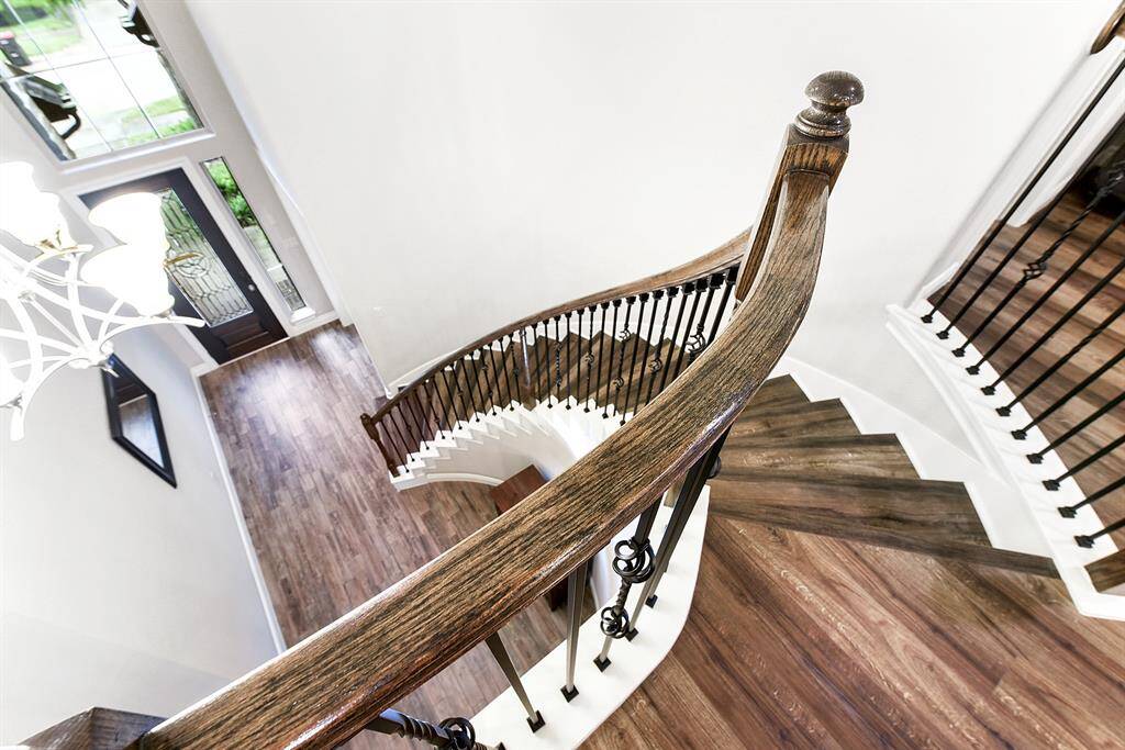 Upstairs, the view overlooking the foyer offers a grand perspective, highlighting the elegant spiral staircase and impressive elevated ceiling heights.