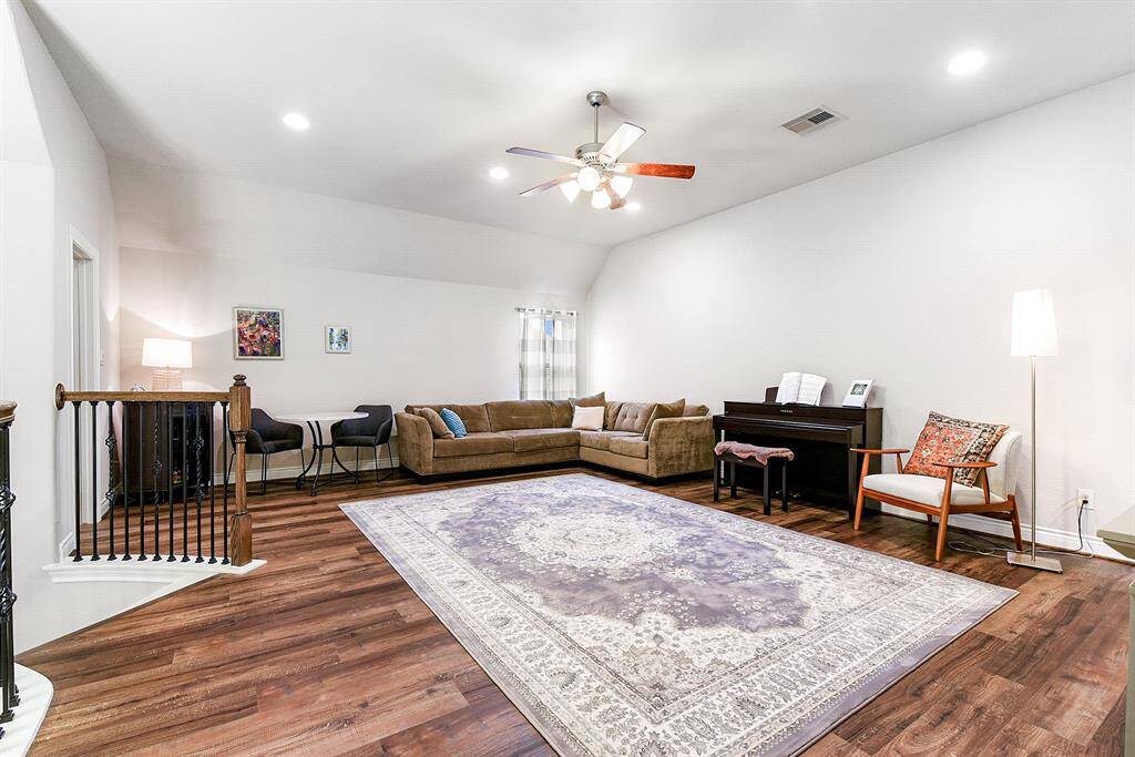 The expansive game room offers ample space, perfect for fitting additional living room furniture, workout equipment, a pool table, and/or game table. It features both a ceiling fan and recessed lighting, creating a comfortable recreational space.