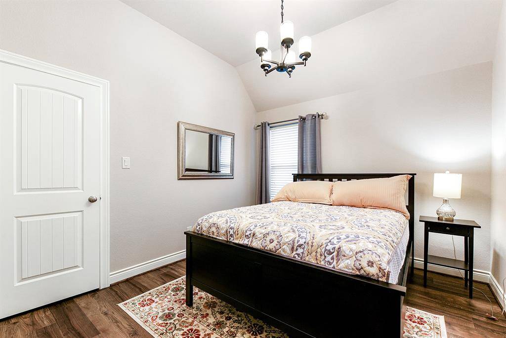 One of the four bedrooms, this guest room shares a two-piece bathroom with an adjacent bedroom, while also featuring a connected double-sink vanity area for added convenience. All bedrooms feature carpet-free flooring.
