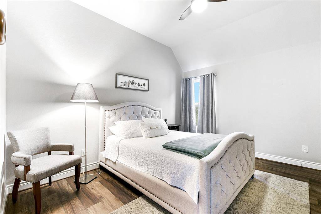 One of the four bedrooms on the second floor is fully equipped with a ceiling fan. A full-size bathroom is conveniently located right next to this bedroom.