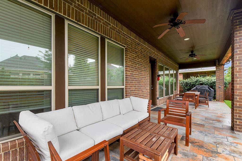 Experience outdoor living at its finest! The expansive covered patio features stylish lighting, dual ceiling fans, tile flooring, and high ceilings, creating the perfect ambiance for evening BBQs and relaxed gatherings.