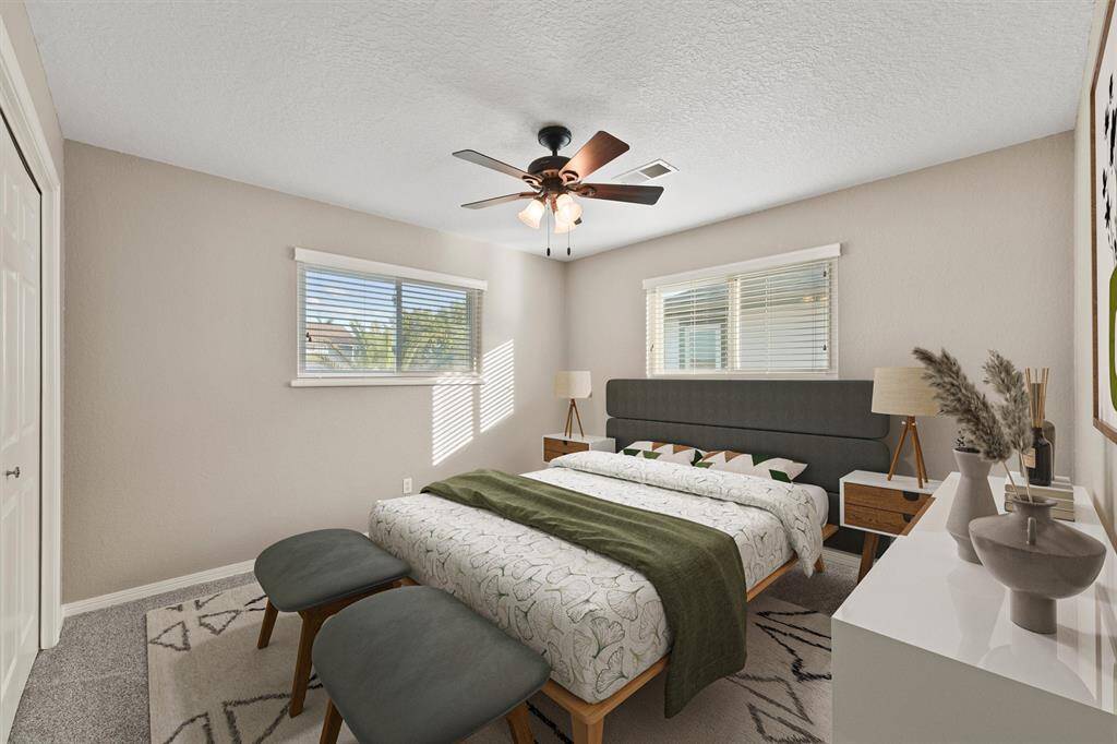 Charming secondary bedroom with double windows, ceiling fan, and soft neutral tones for a cozy feel.