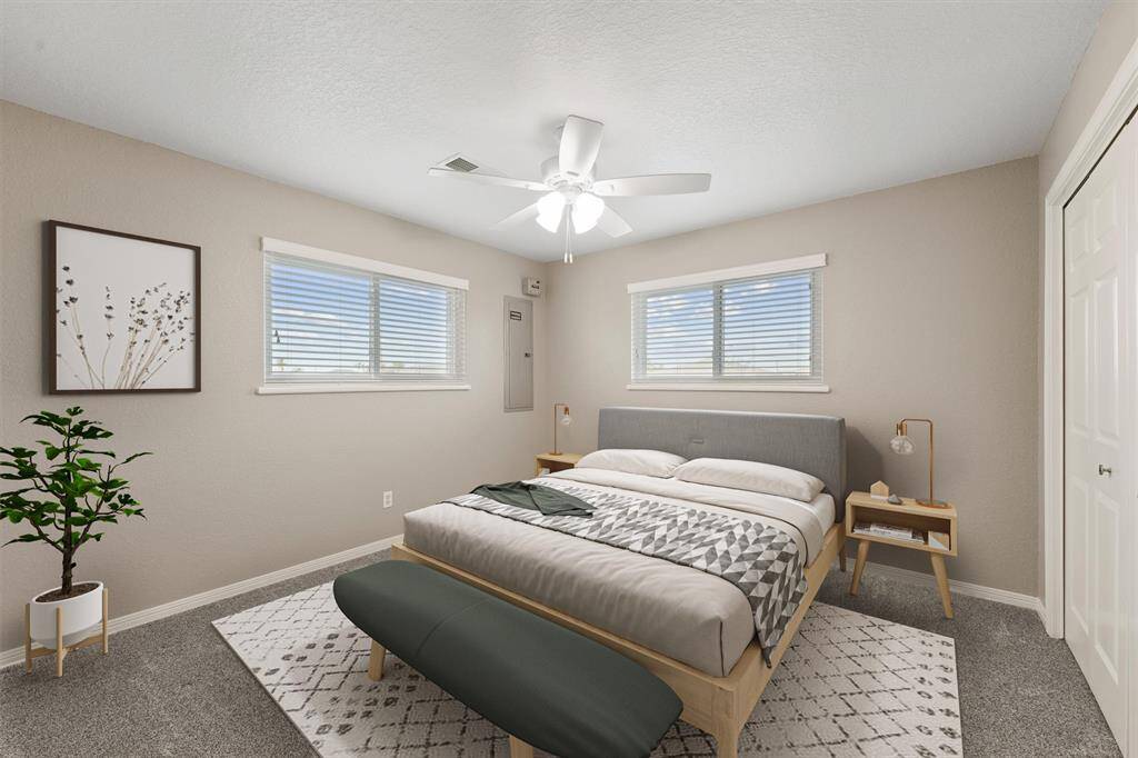 Guest bedroom with ample natural light, ceiling fan, and spacious closet—perfect for visitors or family.