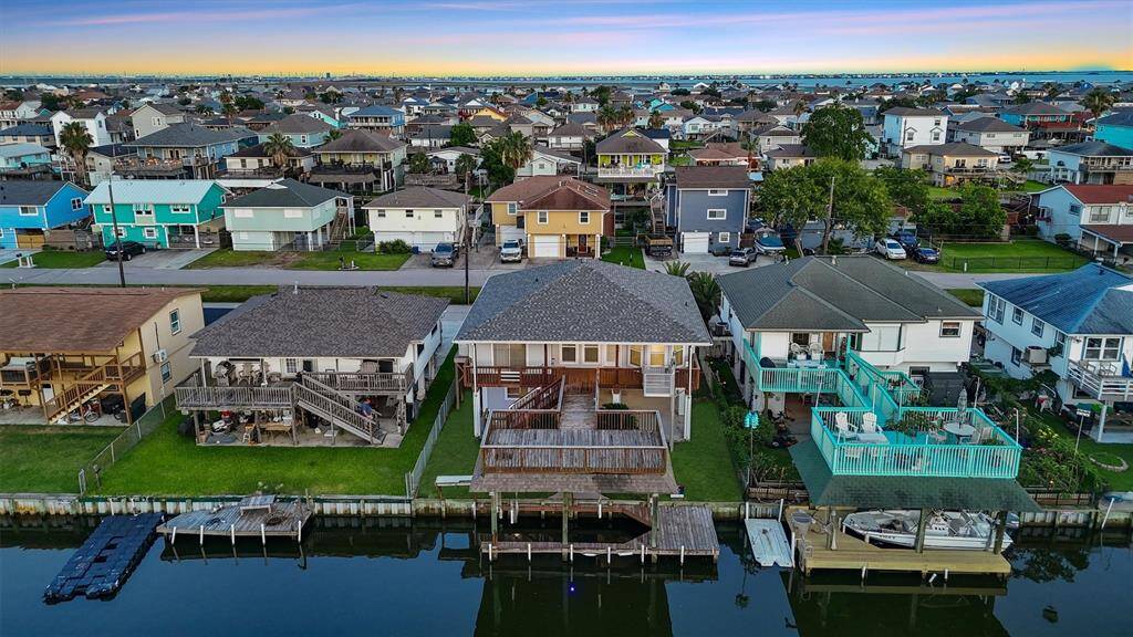 Aerial view showcasing canal access, large deck, and boathouse—true waterfront living at its finest.