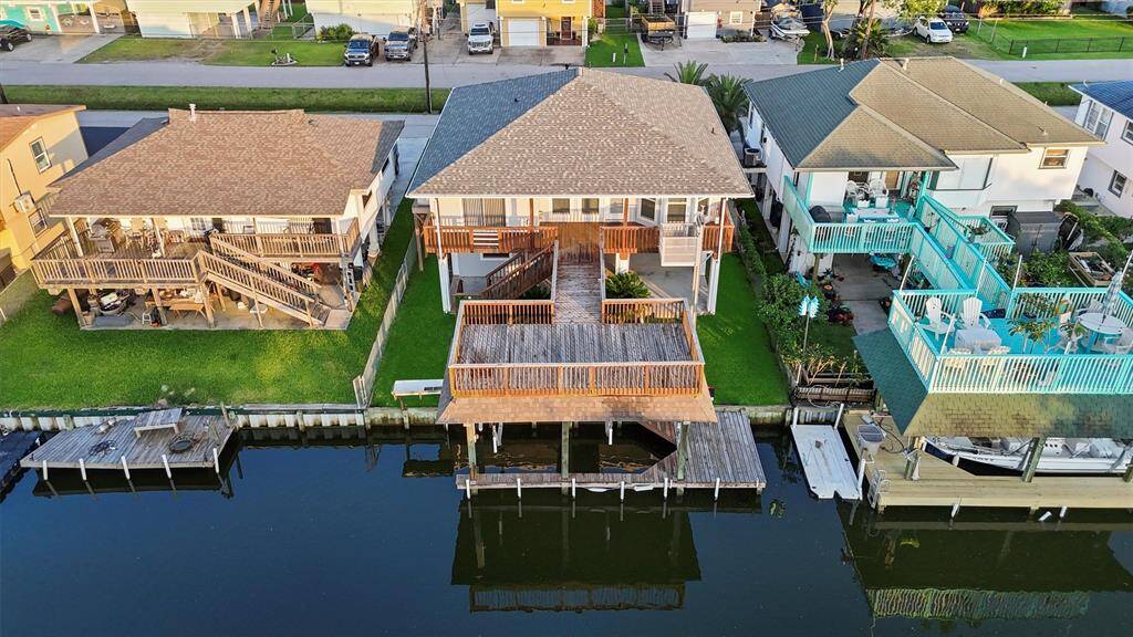 Bird’s-eye view of your private waterfront paradise—complete with a spacious deck, covered patio below, and boathouse with lift for easy canal access.