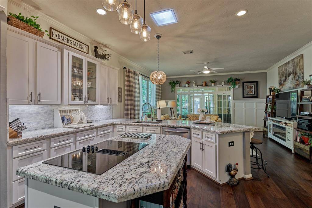 Functional granite prep island with cooktop is conveniently situated in this gourmet kitchen! Note the soft close drawers and cabinets + under cabinet lighting!