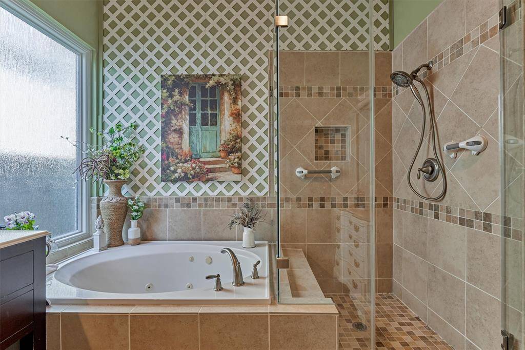 Spa-like jetted tub sits under decorative lattice and privacy glass for bonus lighting. Remodeled shower includes complementary tile selections and seamless surround.