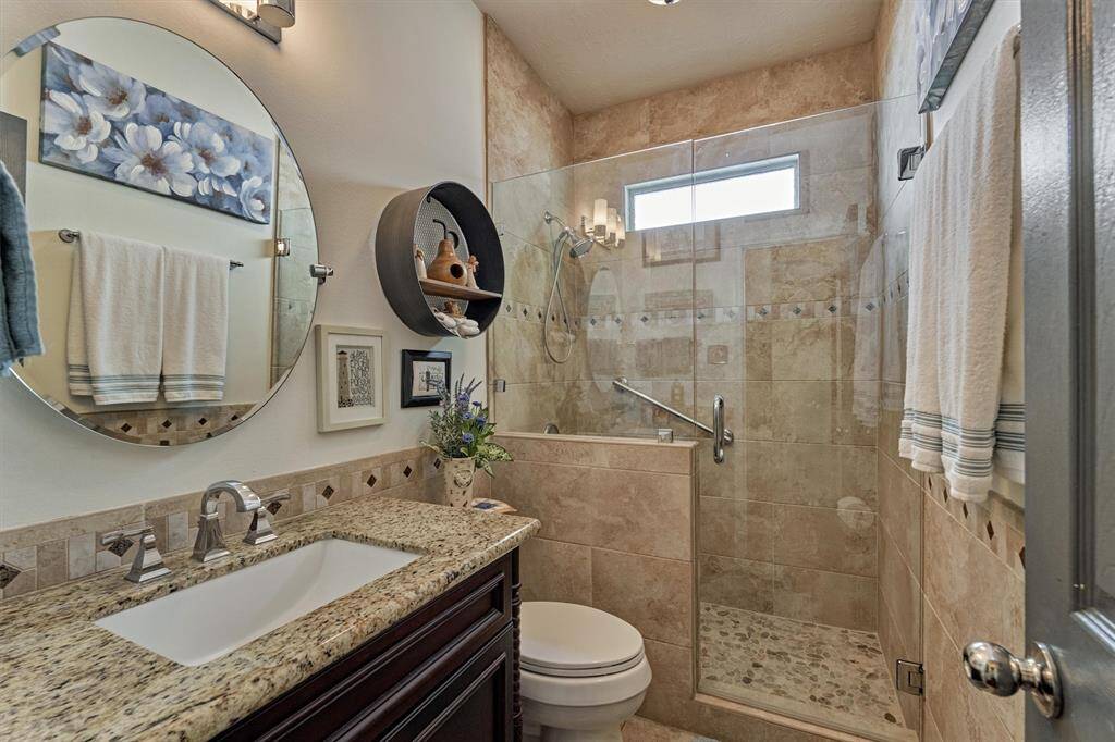 Updated full bath with fully tiled walk in shower and granite vanity.