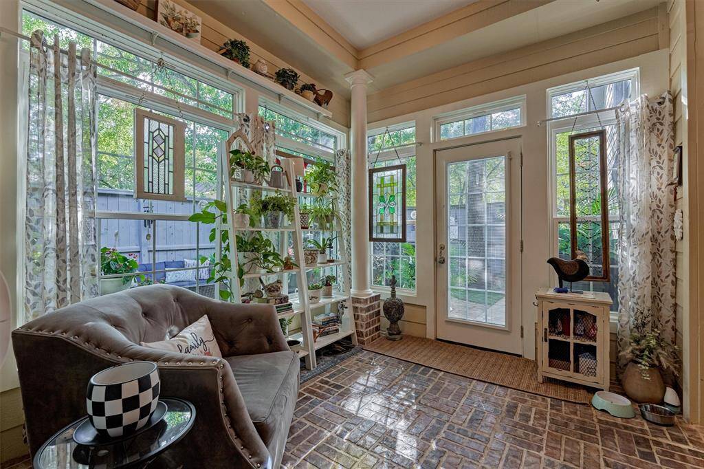 Relax in this welcoming sunroom - an inviting extension of the living space connecting to the manicured gardens in the backyard.