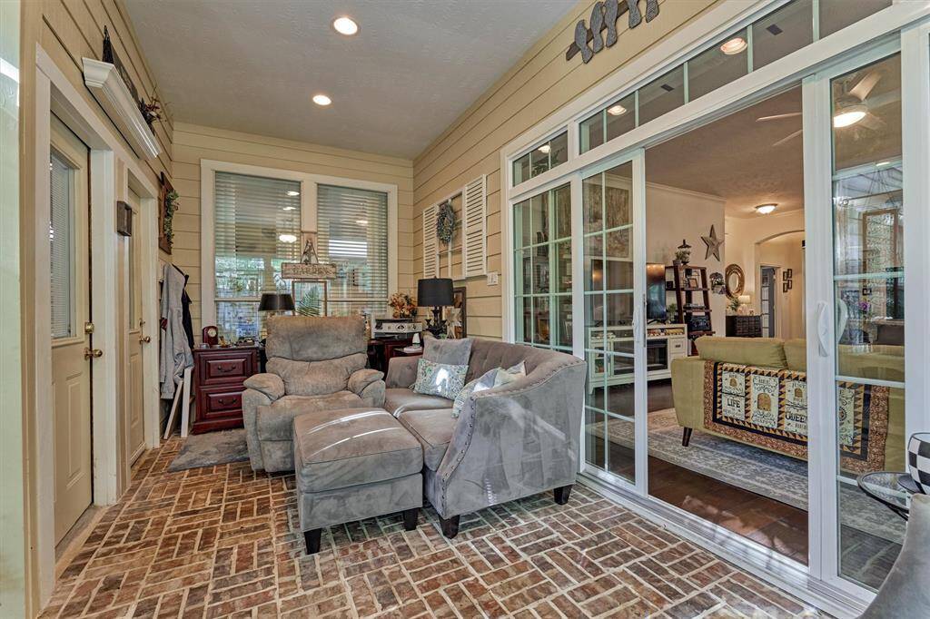 Enclosed patio/sun room with brick pavers and convenient access to the garage apartment staircase.