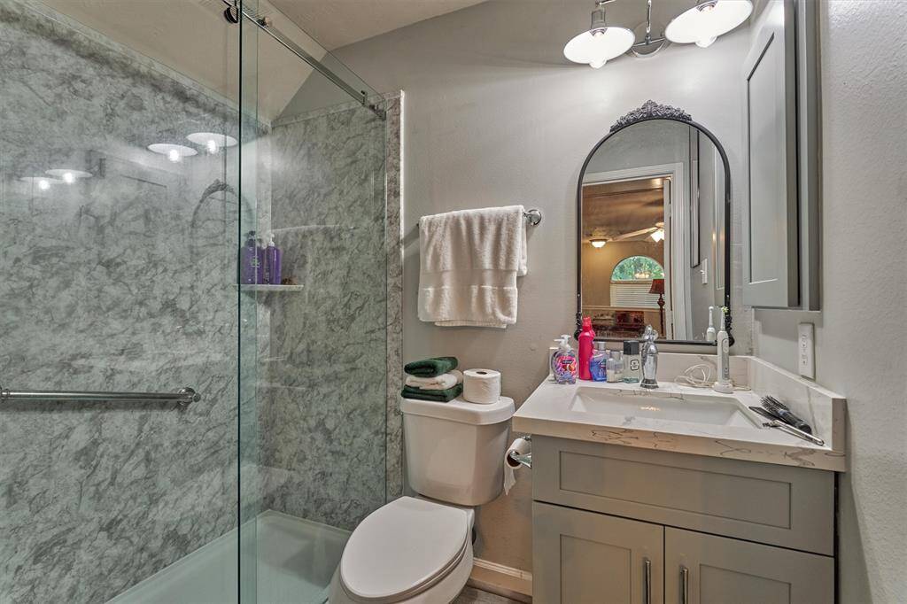 Full bath with seamless stall shower and attractive vanity + medicine cabinet for storage.