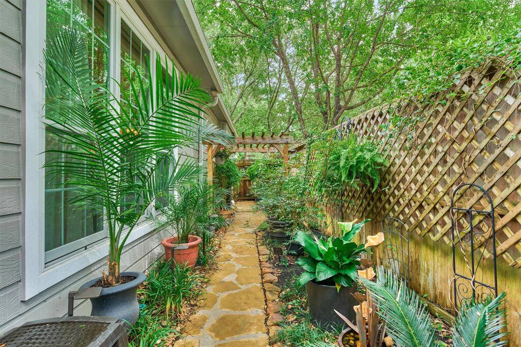 Lush gardens complete the landscape of this Woodlands beauty!