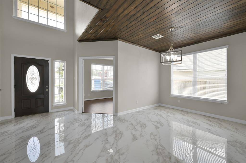 Foyer view from inside. Front door on the left, Office straight, and Dining Room on the right.