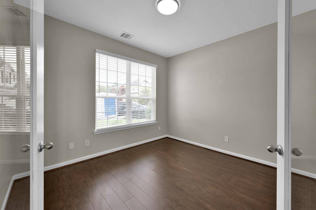 Office with french doors. Looking from the outside looking in. New wood flooring.