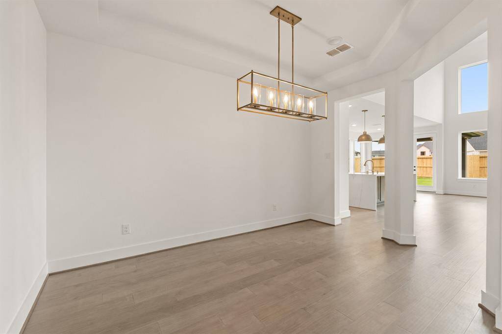 Grand Formal Dining With Classy Lighting & Elegant Hardwoods