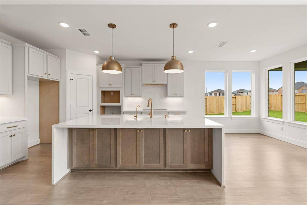 Dream Kitchen With Extra Cabinets & Trendy Pendants