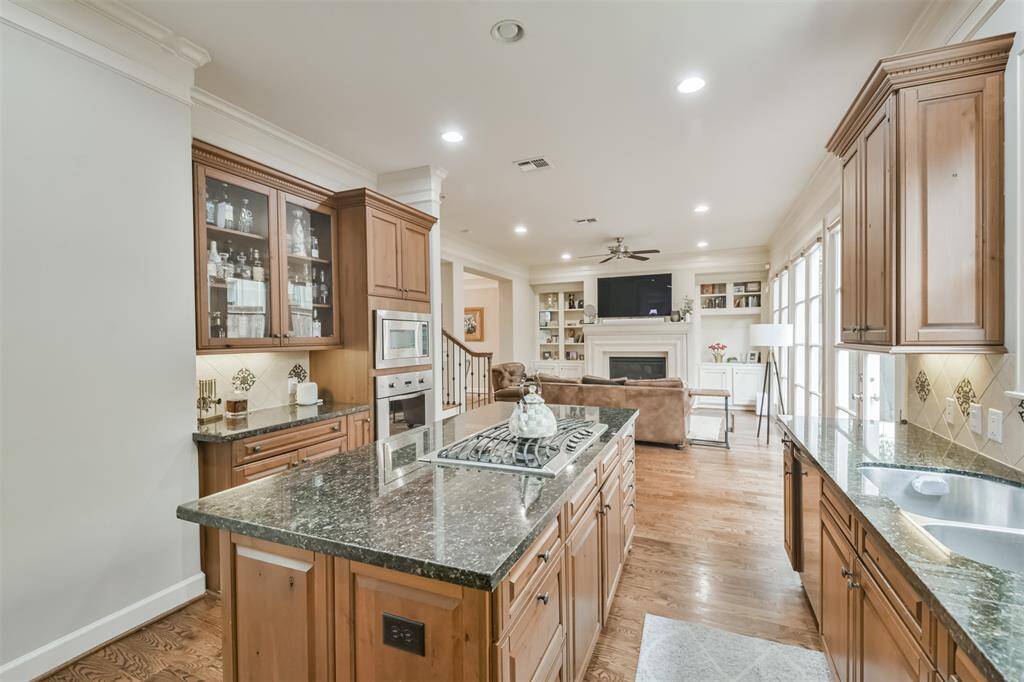 An alternate view of the kitchenoverlooks the inviting livingroom, showcasing granitecountertops, ample cabinetry,and integrated bar space.