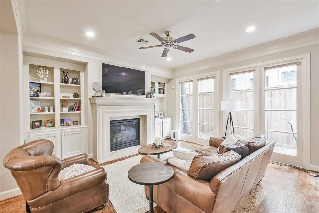 This cozy and elegant livingroom offers custom built-inshelving, a gas fireplace, andexpansive windows bringing inabundant natural light.
