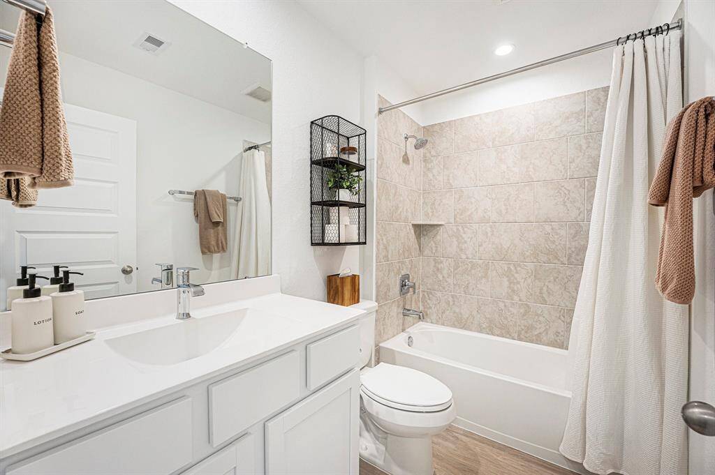 Full secondary bathroom located at the front of the home, featuring a clean, modern design with stylish finishes—perfect for guests or family use.