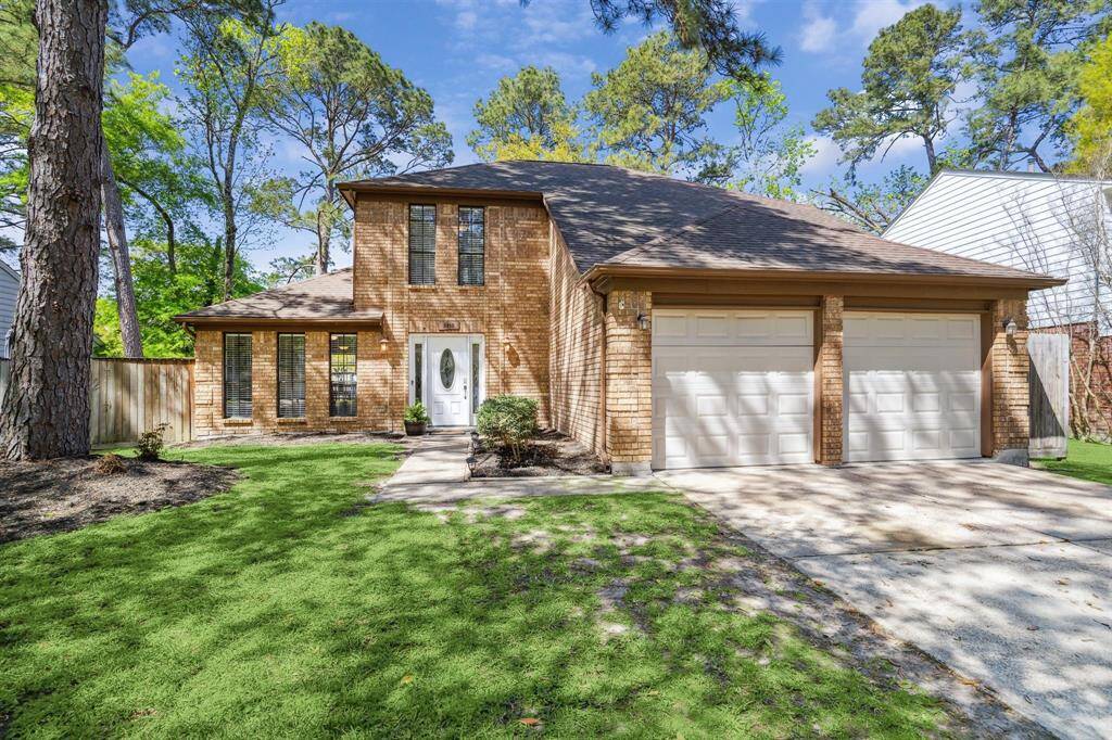This is a charming two-story brick home, surrounded by mature trees,  offers a two-car garage and a welcoming front entrance.