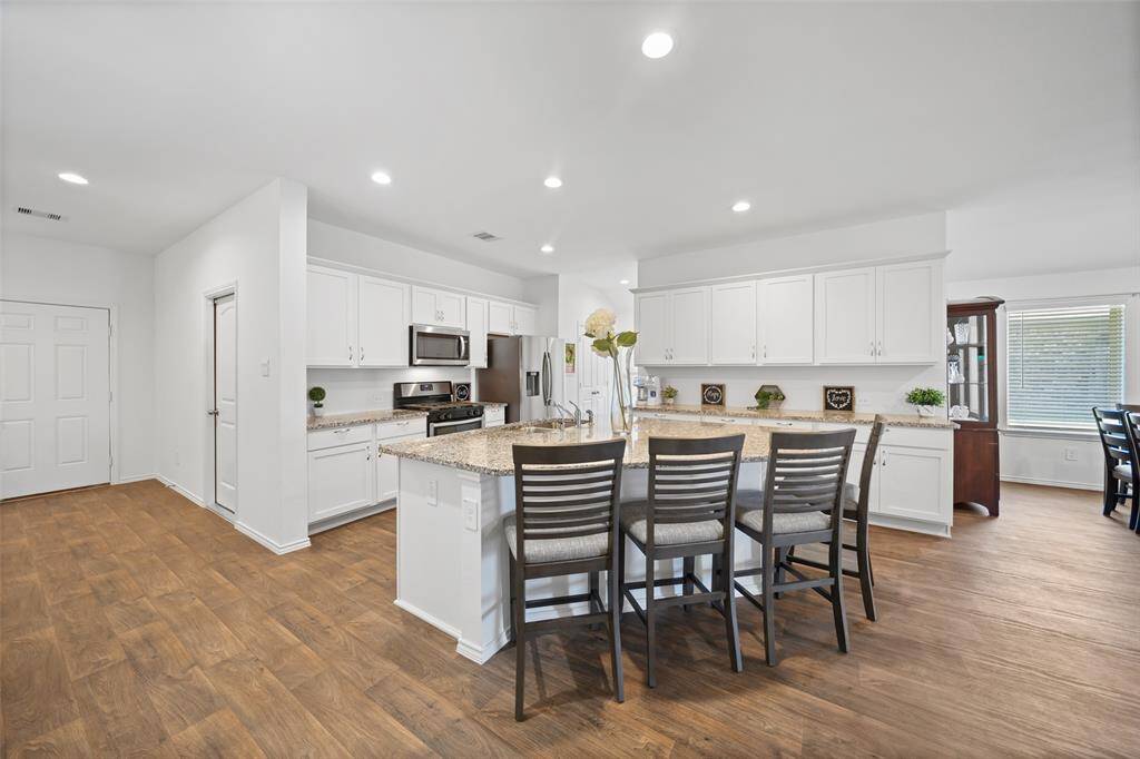 Kitchen features lots of storage cabinets, a double door pantry, SS gas range, refrigerator & dishwasher.