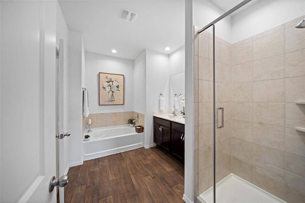 Relaxing spa retreat with soaking tub, separate shower and double vanity sinks.