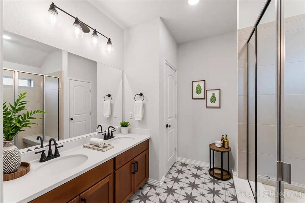 *Staged photo* Discover this bright secondary bathroom with updated vanity, stylish lighting, and a refreshing shower/tub for everyday comfort.