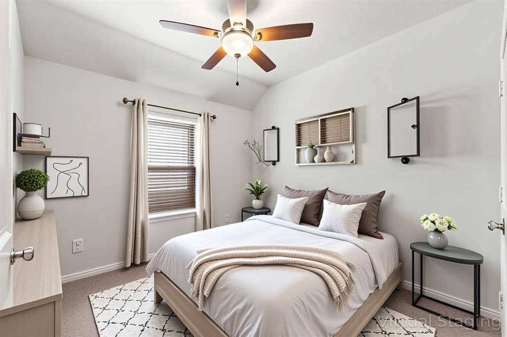 *Staged photo* Enjoy the tranquility and green views from this well-appointed bedroom, complete with a ceiling fan for added comfort.