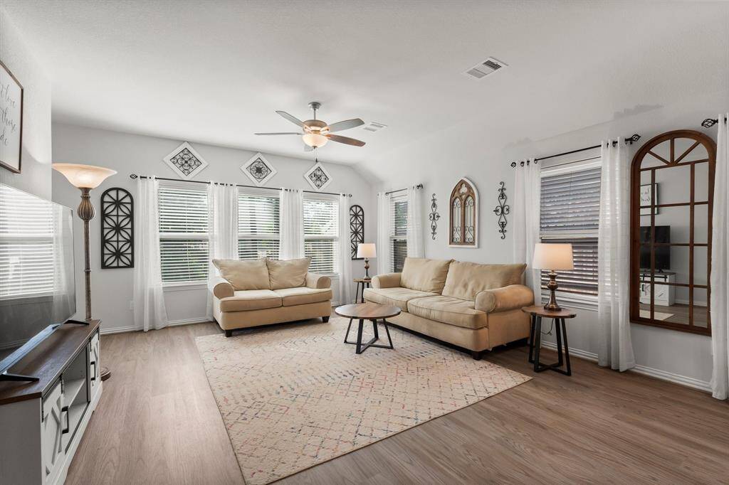 *Staged Photo* Unwind in the bright and airy primary bedroom, boasting large windows that provide a serene view, a stylish ceiling fan for comfort, and generous space for all your furnishings.