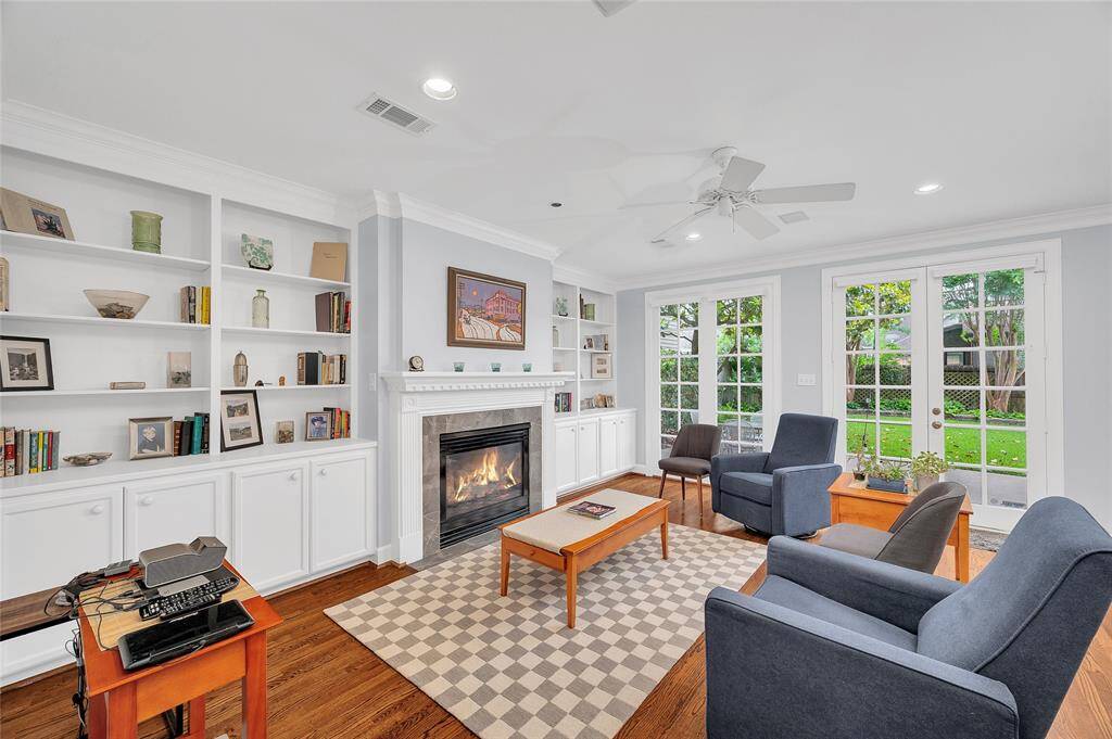 Spacious family room with built-ins, fireplace and a wall of french doors to the backyard