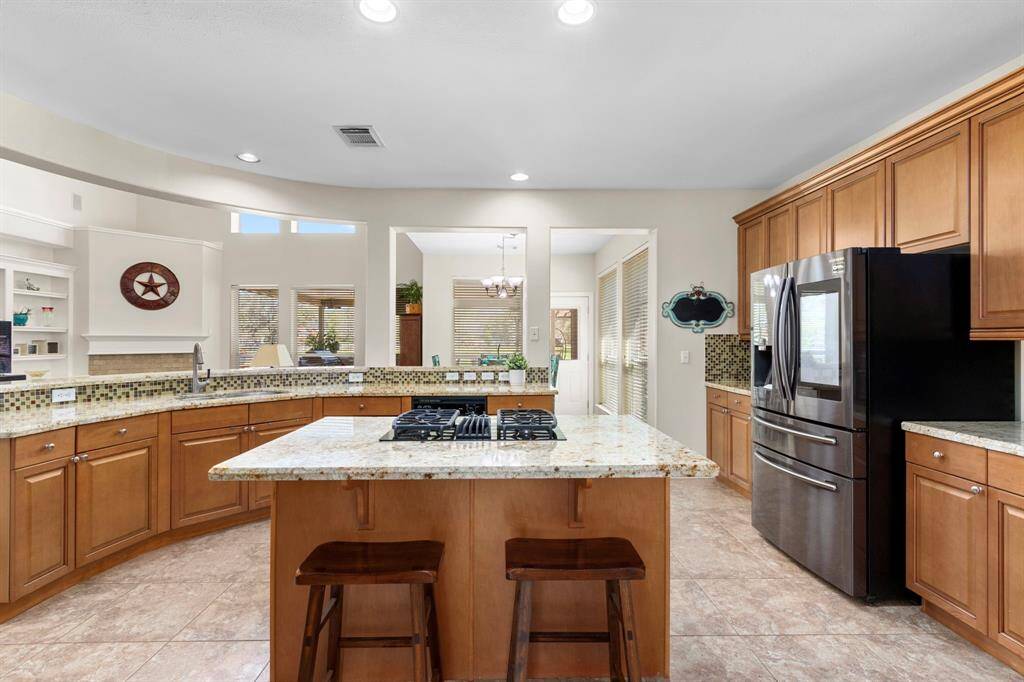 This Kitchen is the heart of the home, seamlessly opening to the Family Room. It boasts abundant counter space, stunning granite countertops, and a stylish glass tile backsplash, combining beauty and functionality for everyday living and entertaining.