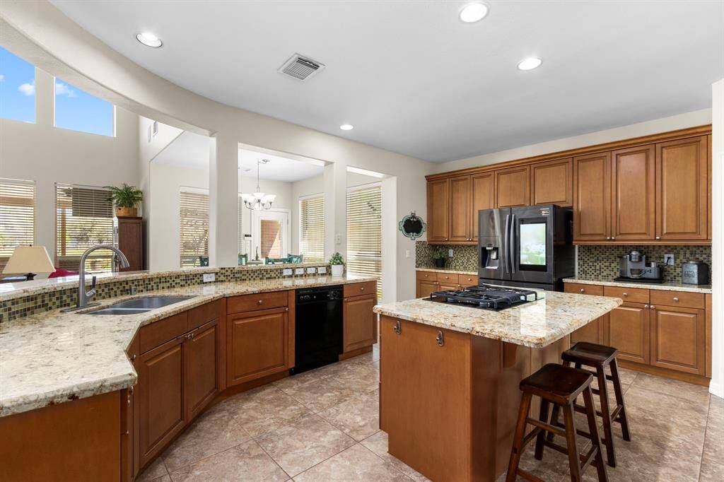 The Kitchen Island features a 4-burner GE Profile gas cooktop and offers additional seating space, making it a perfect spot for cooking, dining, and gathering with family and friends.