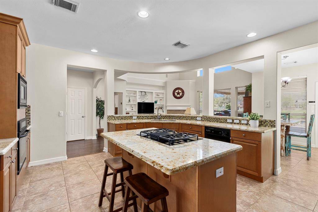 The Kitchen opens to the Family Room, featuring a long Breakfast Bar that provides additional seating for guests and creates a seamless flow for entertaining. A conveniently located Half Bath nearby adds extra comfort and accessibility.