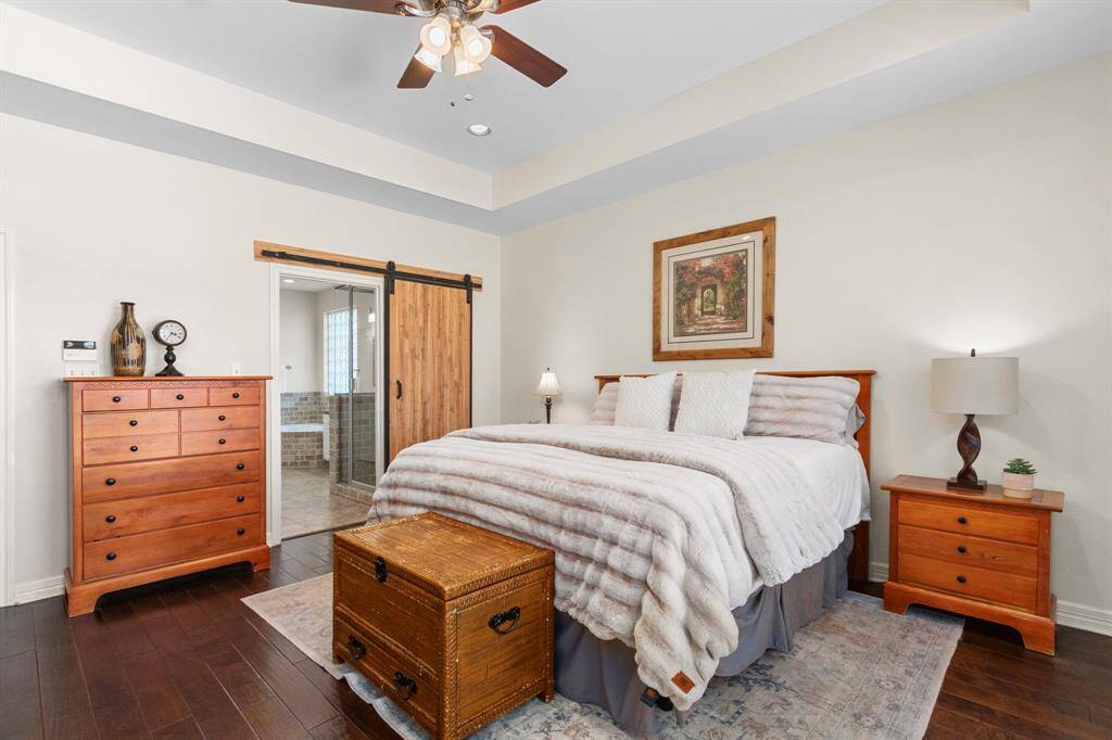 With plenty of wall space to accommodate large furniture, the Primary Suite also features an elegant oil-rubbed bronze ceiling fan and a gorgeous barn door that leads to the Primary Bath.