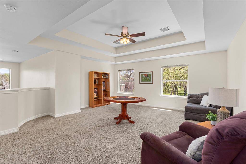 As we make our way to the second floor, you enter this spacious Game Room, large enough to accommodate plenty of seating and entertainment. It features a double pop-up ceiling and large windows that fill the space with natural light, creating a bright and inviting atmosphere.