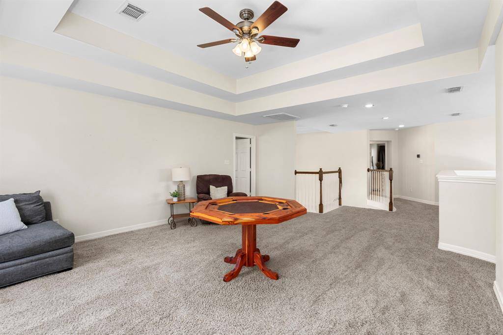 The opposite side of the room highlights its expansive size, large enough for a pool table and game tables. A stylish ledge overlooks the downstairs Family Room, enhancing the home's open and connected feel.