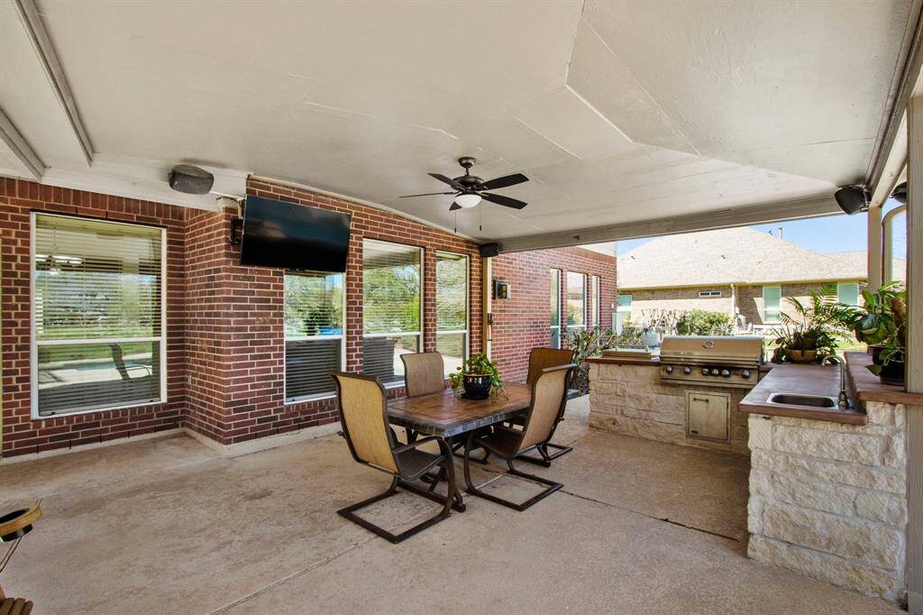 This space also features a built-in kitchen with a stainless steel undermount sink, a stained concrete countertop, and a built-in Lion beverage refrigerator, all beautifully surrounded by Austin stone brick. Please note that the Lion cooktop grill is not operable and will need to be replaced.