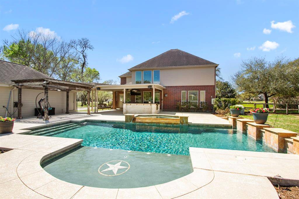 This view from the opposite side showcases the Texas star proudly displayed, along with a relaxing tanning ledge, adding both charm and functionality to the pool area.