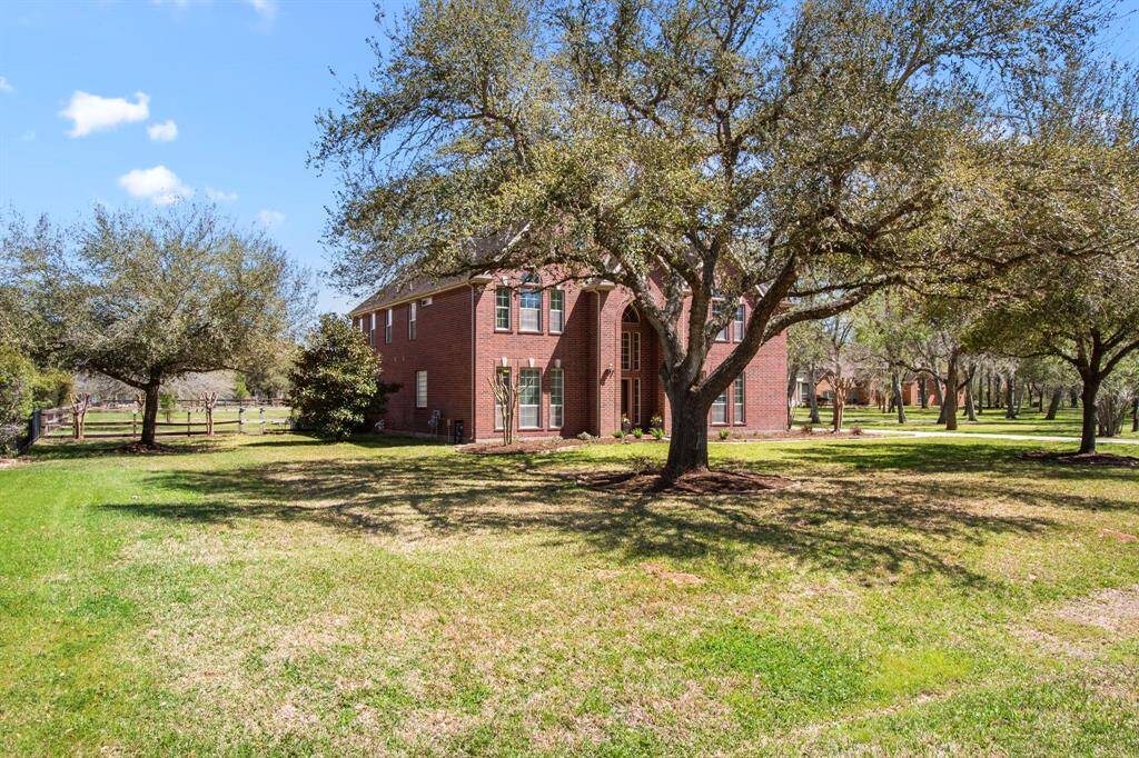 The front elevation of this home features a distinguished gable roofline with concrete corbels, complemented by rich brick tones. An inviting covered porch is framed by a graceful archway, while elegant coach lights add the finishing touch, enhancing the home’s timeless curb appeal.